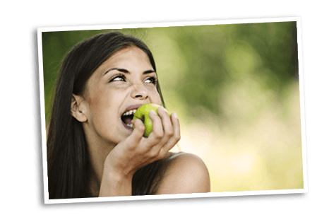 Young woman eating a green apple