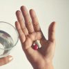 Hands Holding Pills And A Glass Of Water