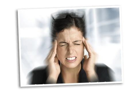 Brunette woman holding her temples and the background is motion blurred