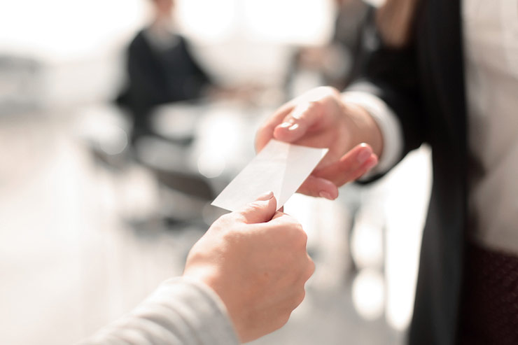 Person handing someone a business card