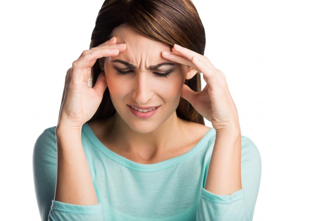 Brunette woman holding her head