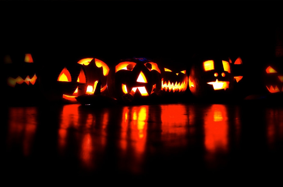 Several carved Halloween pumpkins with candles in them