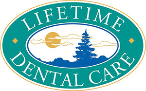 Lifetime Dental Care Logo - White serif type on turquoise background with gold sun and blue trees in center