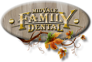 Midvale Family Dental Logo - Gold serif type engraved into wood plaque with fall leaves at the bottom