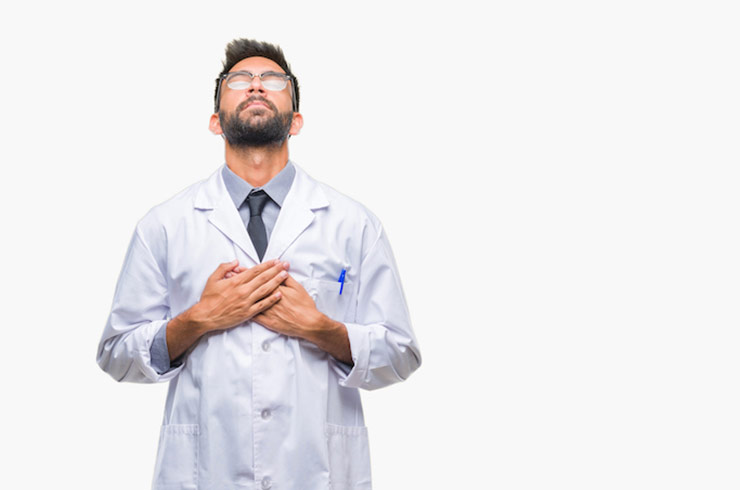 Doctor with hands over heart looking upward