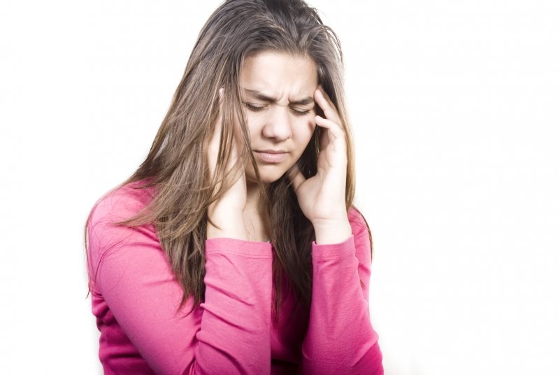 Young girl holding her head