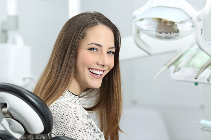 Happy female patient in dental chair