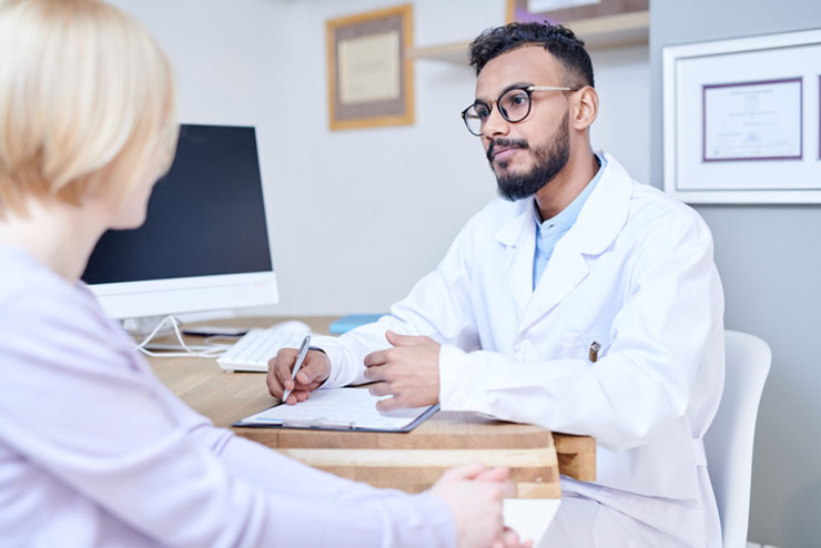 Male doctor speaking to female patient