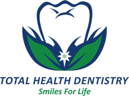 Total Health Dentistry Logo - Green and blue sans-serif type with tooth on bed of leaves on top